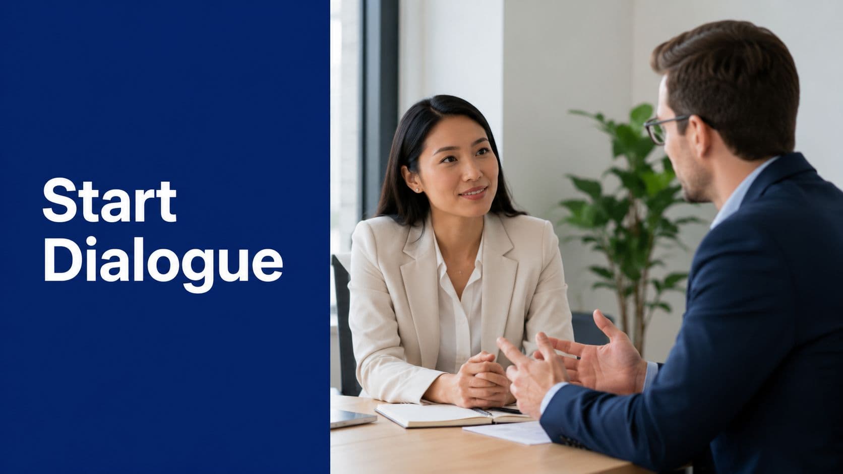 A professional woman and a businessman engaged in a formal meeting at an office desk.