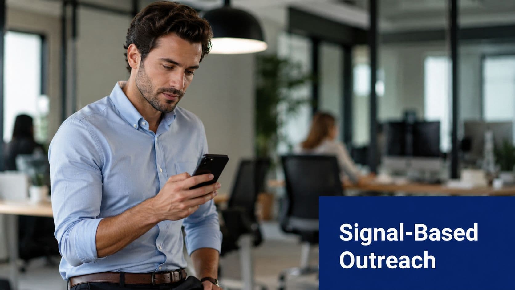 A professional man checking his smartphone while sitting in a modern corporate office workplace environment.